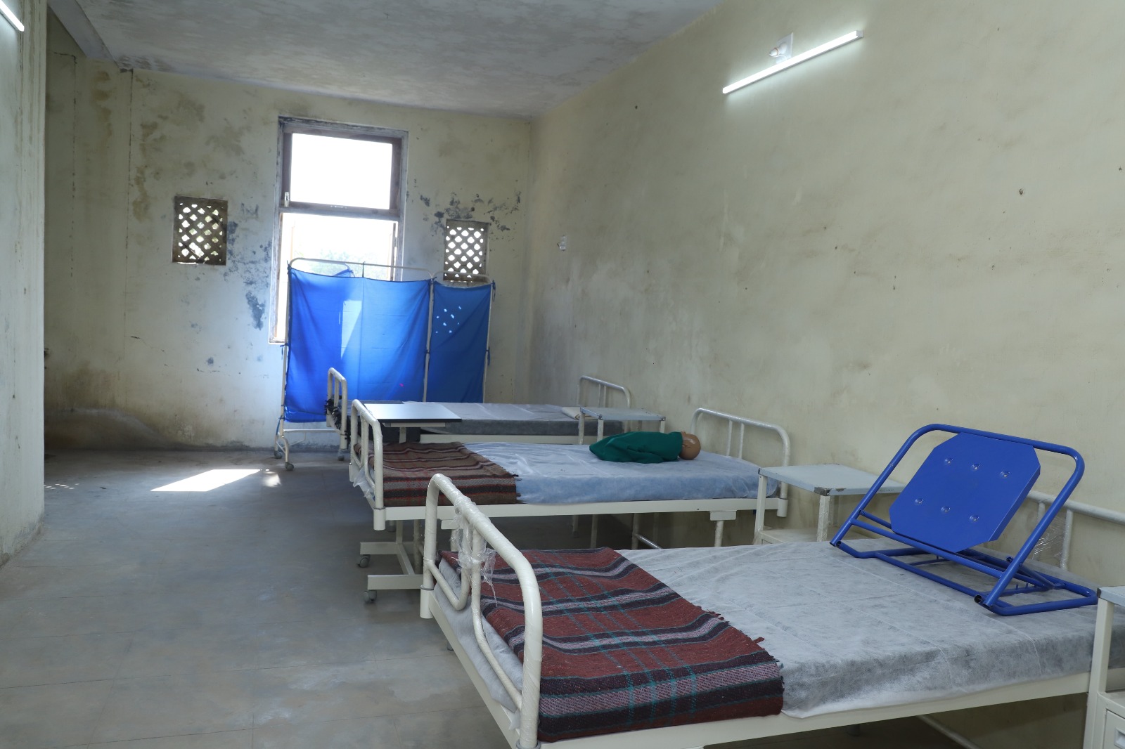 person writing in a notebook beside by an iPad, laptop, printed photos, spectacles, and a cup of coffee on a saucer